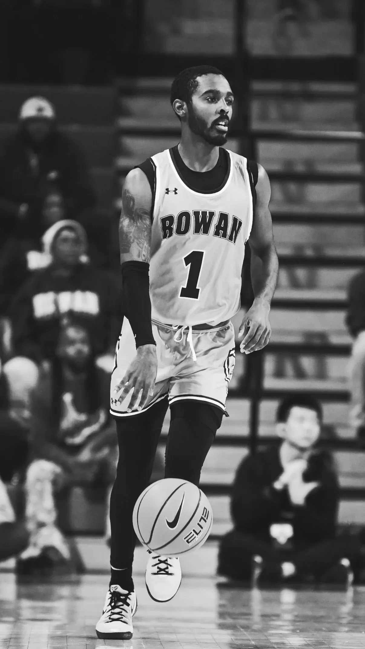 Fareed Burton Jr. dribbling in a white Rowan College number one jersey